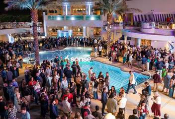 Large corporate event around illuminated pool at tropical resort venue