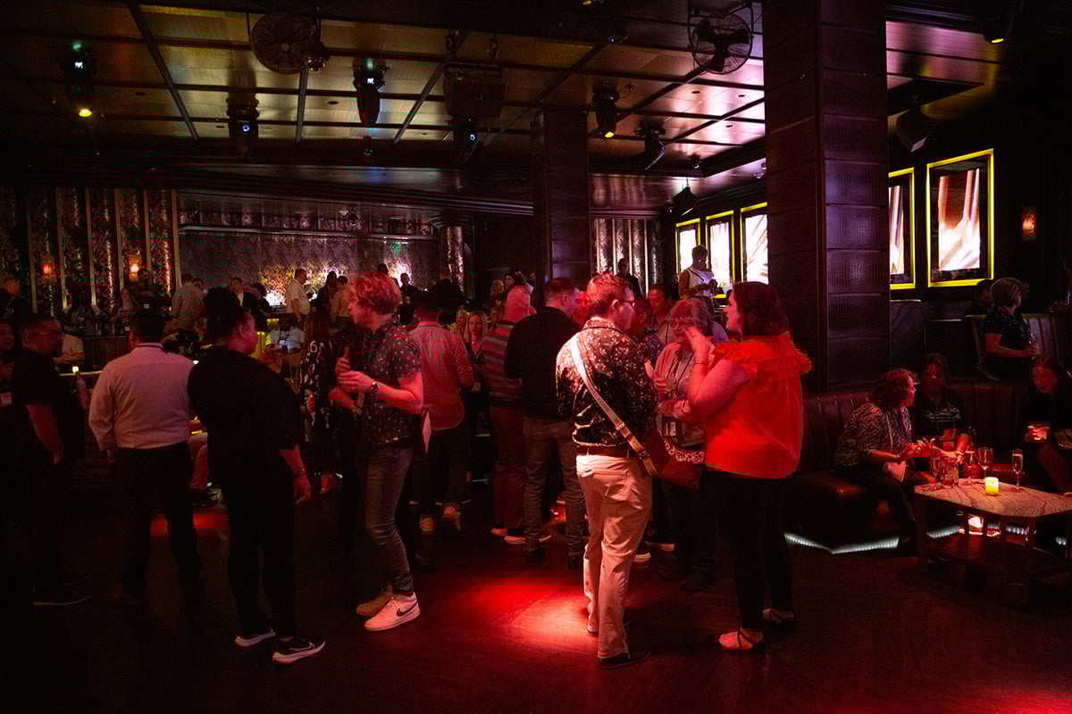 Guests mingling in dimly lit Las Vegas lounge with red ambient lighting